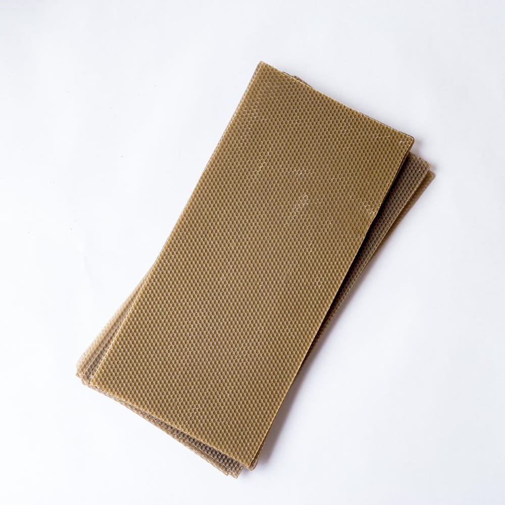 Stack of golden embossed pure beeswax sheets for frame foundation